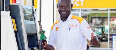 Happy employee holding the petrol pump nozzle